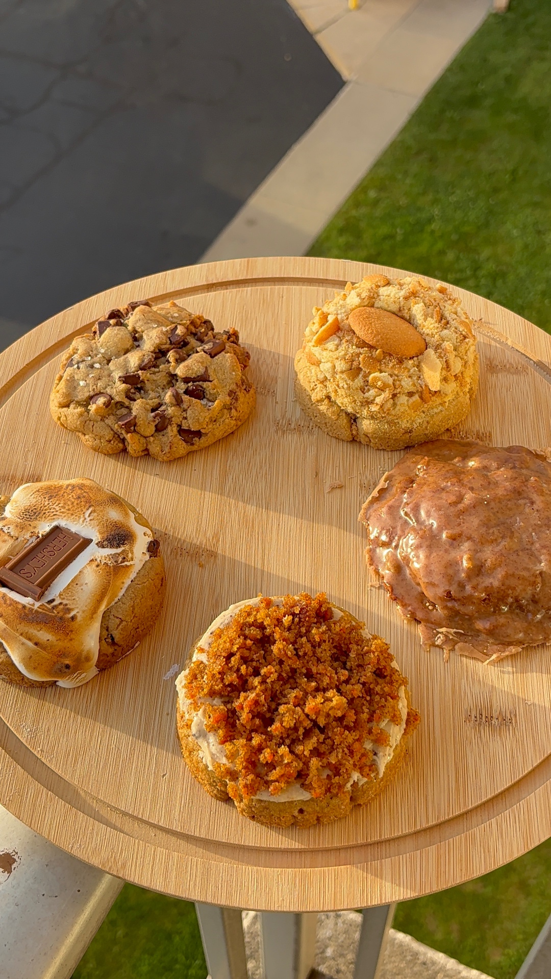 Five gourmet cookies on a wooden serving board