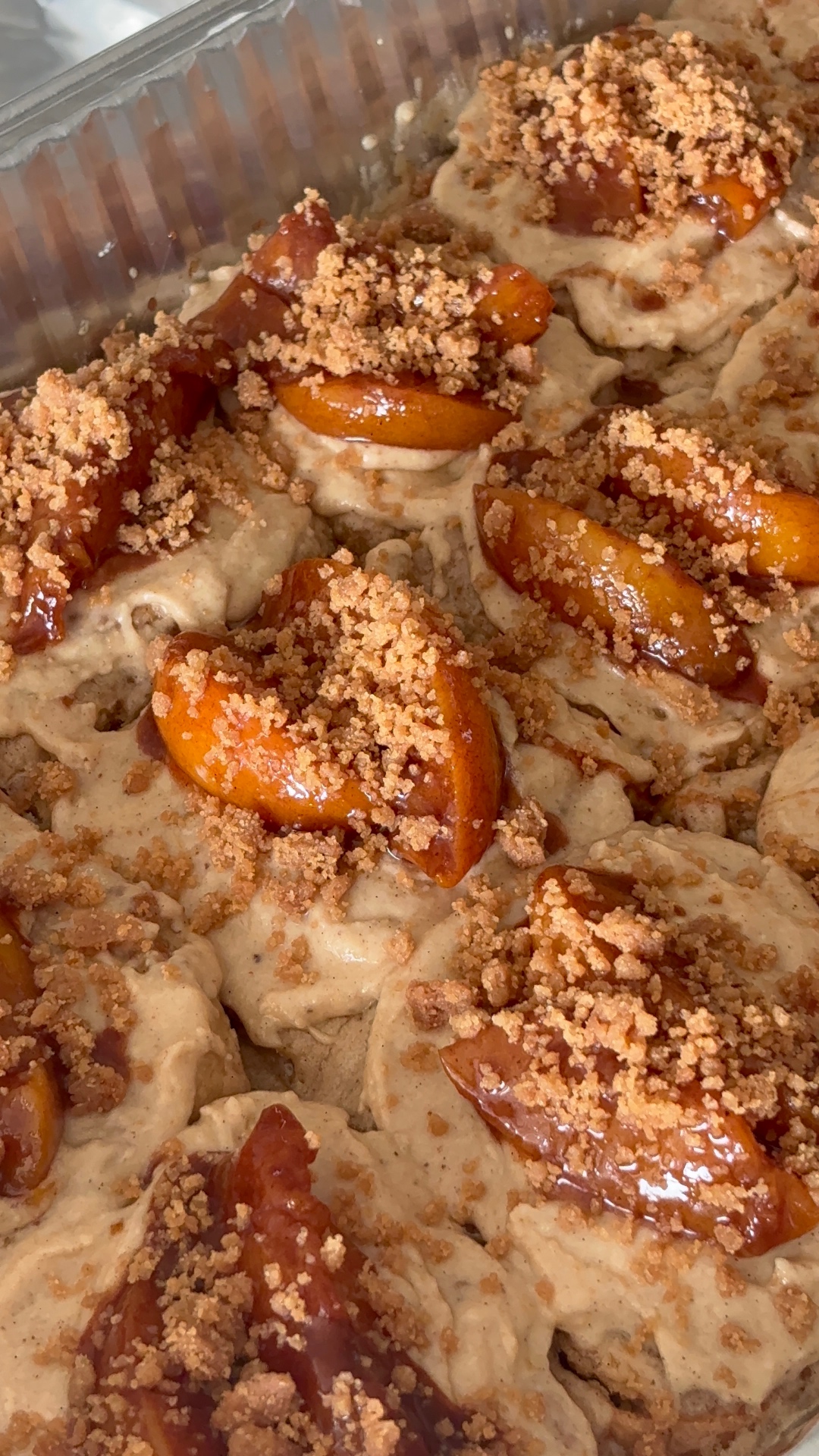 Peach cobbler cookies topped with glazed peaches and cinnamon crumble